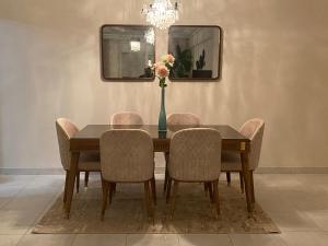 a dining room table with chairs and a vase with flowers at Résidence les Dunes- S+3 -Chott Meriem Kantaoui Sousse in Chott Meriem