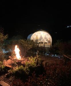 a fire in front of a domed building at night at Origen Glamping en Villa de Leyva in Villa de Leyva