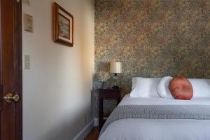 1 dormitorio con 1 cama y papel pintado con motivos florales en Historic Hotel Packwood en Packwood