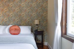 Schlafzimmer mit einem Bett mit orangefarbenem Kissen in der Unterkunft Historic Hotel Packwood in Packwood