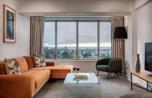 a living room with a couch and a large window at Rydges Rotorua in Rotorua