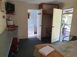 a room with a bed, a refrigerator, and a television at Affordable Gold City Motel in Charters Towers