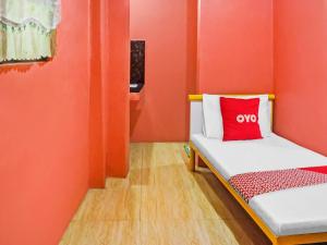 マニラにあるOYO 868 Solanos Transient Houseの赤い枕付きのベンチが備わる赤い部屋