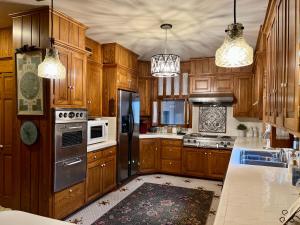 uma cozinha com armários de madeira e electrodomésticos de aço inoxidável em THE CW HOUSE em Claude