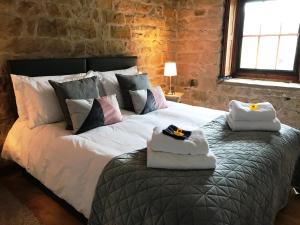 a bedroom with a large bed with towels on it at Heather Cottage Bakewell in Bakewell