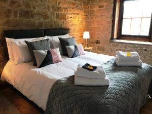 ein Schlafzimmer mit einem großen Bett mit Handtüchern darauf in der Unterkunft Heather Cottage Bakewell in Bakewell