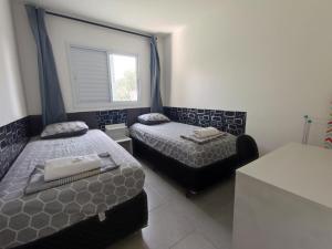 um quarto com 2 camas e uma janela em Apartamento próximo ao shopping em Poços de Caldas