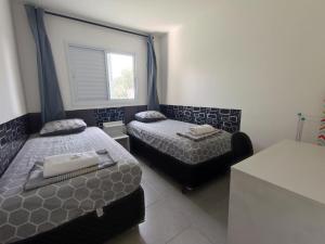 a bedroom with two beds and a window at Apartamento próximo ao shopping in Poços de Caldas