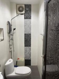 a small bathroom with a toilet and a shower at Villa Prisha in Bayan Lepas +9 photos