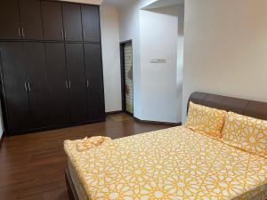 a bedroom with a bed with a yellow blanket at Villa Prisha in Bayan Lepas