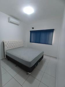 ein Schlafzimmer mit einem Bett in einem Zimmer mit Fenster in der Unterkunft Casa linda caldas novas in Caldas Novas