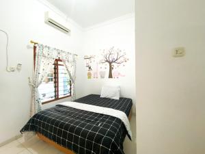 Giường trong phòng chung tại Homey Guesthouse Kertajaya (Syariah)