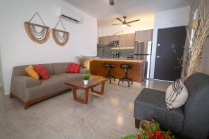 a living room with a couch and a table and a kitchen at Casa Jaguar in Puerto Morelos