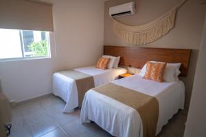a hotel room with two beds and a window at Casa Jaguar in Puerto Morelos +73 photos
