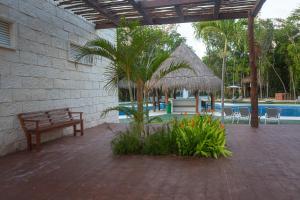 a patio with a bench and a swimming pool at Casa Jaguar in Puerto Morelos