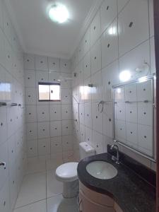 ein weißes Badezimmer mit Toilette und Waschbecken in der Unterkunft Casa linda caldas novas in Caldas Novas