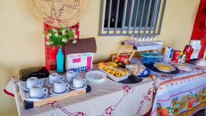 a table topped with dishes and cups and food at Pousada do Mané in Santo Amaro