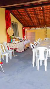 a group of white tables and chairs in a room at Pousada do Mané in Santo Amaro