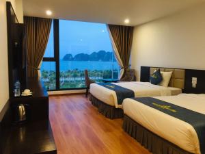 下龍灣的住宿－Golden Palm HaLong Hotel，酒店客房设有两张床和大窗户。