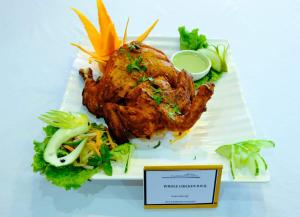 a plate of food with a fried chicken and vegetables at Hotel Pauwa Pokhara in Pokhara