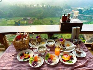 a table with plates of food on a table with a view at สายหมอกบอกรัก น่าน SAIMOK Bokrak NAN in Ban Huai Ti +35 photos