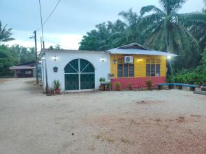 a house with a yellow and white at Homestay Patonah 1 in Gerisik