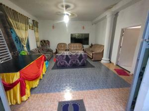 een woonkamer met een tafel en een bank bij Homestay Patonah Kampung Sawah Ring in Gerisik