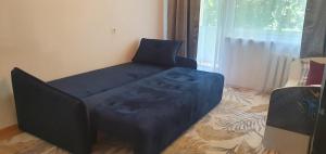 a blue couch in a room with a window at Krymo g. Lovely 2 room flat in Šiauliai, near Akropolis in Šiauliai