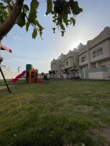 un parc avec une aire de jeux en face d'un bâtiment dans l'établissement فلل السيف الخاصة, à Abha
