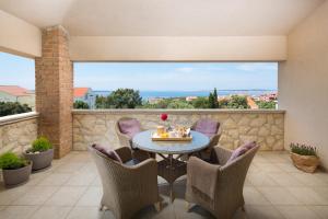 a patio with a table and chairs and a stone wall at Villa Pag in Mandre