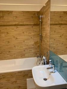 a bathroom with a sink and a bath tub at Apartament nemaipomenit, nou, in Complex Rezid Ared in Arad +6 photos