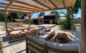 a patio with a wooden pergola and a table at La maison coup de cœur de Pont Caffino 9 couchages plus 2 sur demande in Maisdon-sur-Sèvre +16 photos