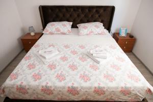 a bed with a quilt and two towels on it at Amaryllis in Rogoznica