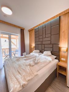 a bedroom with a large bed with two swans on it at Sylpaulerhof Aparthotel in Sankt Michael im Lungau