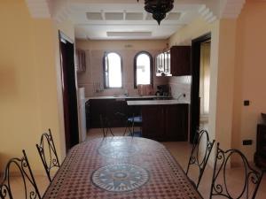 uma sala de jantar com uma mesa e uma cozinha em Appartement dans villa em Cite Adrar