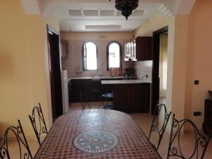 een eetkamer met een tafel en een keuken bij Appartement dans villa in Cite Adrar