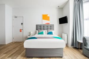 ein Schlafzimmer mit einem großen Bett und einem Stuhl in der Unterkunft OYO Studiotel GY - Modern Hotel Apartments in Great Yarmouth