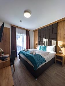a hotel room with a large bed and a desk at Sylpaulerhof Aparthotel in Sankt Michael im Lungau