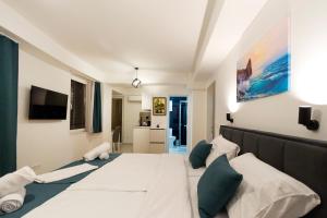a bedroom with two beds and a tv on the wall at Gric Apartments in Ohrid