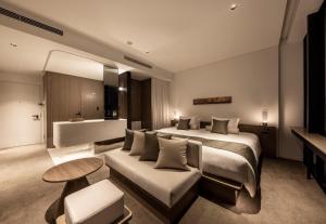 um quarto de hotel com uma cama e um sofá em The Royal Park Hotel Iconic Kyoto em Quioto