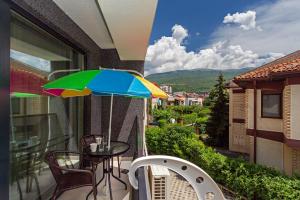 a balcony with a table and a colorful umbrella at Gric Apartments in Ohrid