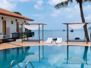 a swimming pool with a view of the ocean at Koh Tao Heritage in Koh Tao