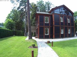 a large wooden house in a green yard at Exquisite 1930's Historical House in Jūrmala
