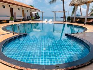 a swimming pool with blue tiles in front of the ocean at Koh Tao Heritage in Ko Tao