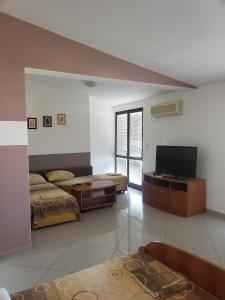a living room with two beds and a flat screen tv at Apartments Petricevic in Sutomore