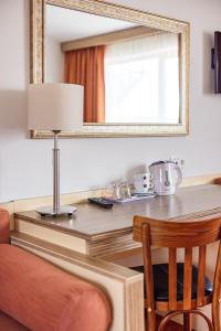 een tafel met een spiegel en een tafel met een stoel bij Info Hotel in Palanga