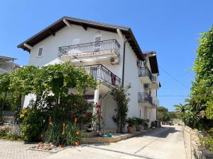 a white building with balconies and flowers in front of it at Apartments Logos in Trogir