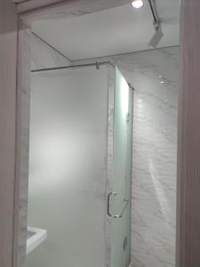 a bathroom with a shower with a white marble wall at "AIKO" Konak Otbasy in Shymkent