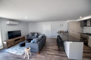 een keuken en een woonkamer met een bank en een televisie bij Albatross Retreat in Inverloch