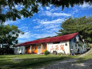 太麻里的住宿－山采家民宿，一间有红色屋顶的房子,上面涂有涂鸦